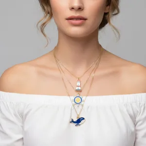 Collana dorata a strati con ciondoli in smalto colorato a forma di balena e faro.