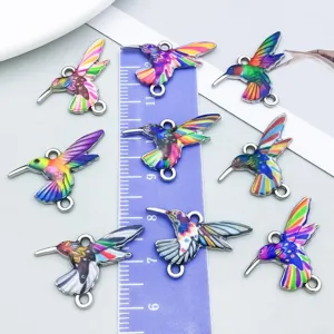 Detailed close-up view of ten colorful enamel hummingbird charms for DIY jewelry making