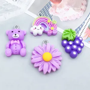 Detailansicht niedlicher lila Harz-Anhänger mit Bär, Regenbogen, Blume und Weintrauben.