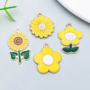 Close-up of four assorted yellow enamel sunflower and daisy pendants for DIY jewelry