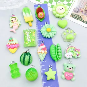 Detailansicht verschiedener grüner Cartoon-Resin-Anhänger für DIY-Schmuck mit Lineal