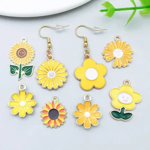 Close-up detail of yellow enamel sunflower and daisy flower charms for DIY jewelry making.