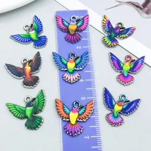 Dettaglio di ciondoli a forma di colibrì in smalto colorato per gioielli DIY con righello