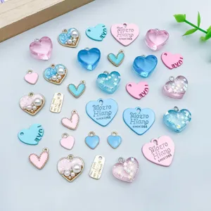 Vista dettagliata di vari ciondoli a cuore in resina blu e rosa per gioielli fai-da-te