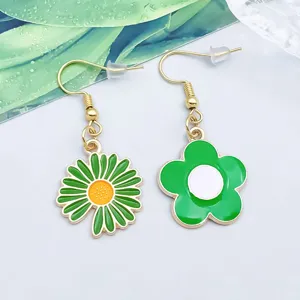 Detaillierte Nahaufnahme grüner Emaille-Blumenohrringe mit goldfarbenen Haken und Anhängern