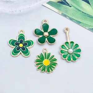 Nahaufnahme verschiedener grüner Emaille-Blumenanhänger für die handgefertigte DIY-Schmuckherstellung.