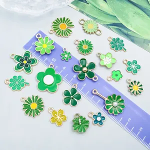 Nahaufnahme von grünen Emaille-Blumenanhängern mit einem Lineal zur Größenbestimmung