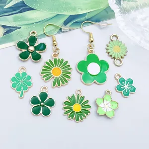 Detailansicht verschiedener grüner Emaille-Blumen- und Kleeblattanhänger für DIY-Schmuck