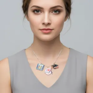 Close-up of enamel graduation charms on a necklace worn by a model