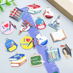 Detailed view of colorful school-themed enamel charms with ruler for size scale
