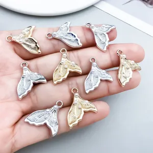 Detailed view of mermaid tail pendants with white pearls in gold and silver finishes