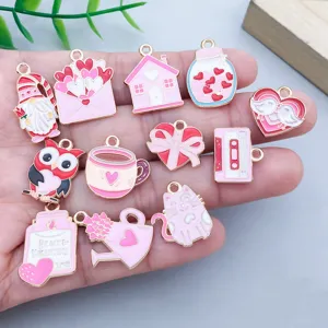 Close-up of pink enamel Valentine's Day charms featuring hearts, cats, and envelopes