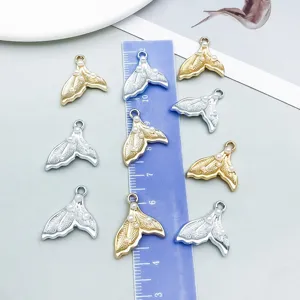 Macro detail of pearl-studded mermaid tail pendants with scale ruler for sizing
