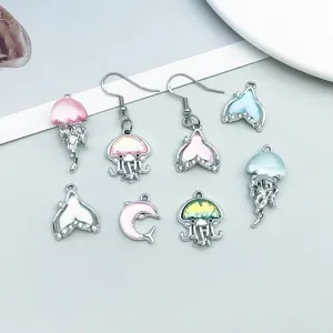 Vista detallada de dijes de vidrio de medusa y delfín para creación de joyas DIY