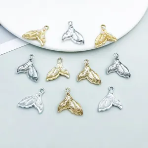 Detailed macro view of pearl-embellished mermaid tail charms in gold and silver finish
