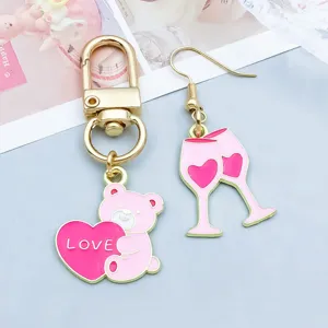 Vue détaillée de breloques ours et verre à vin en émail rose pour bijoux DIY de la Saint-Valentin.