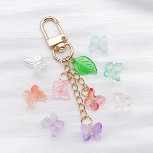 Close-up of colorful gradient butterfly charms and gold keychain on white fabric