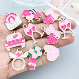 Gros plan de breloques de la Saint-Valentin en émail rose aux motifs de cœur et d'ours DIY.