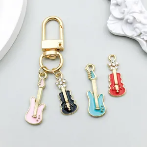 Detailed view of colorful enamel guitar and violin charms with gold lobster clasp