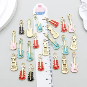 Macro view showing various colorful enamel guitar charms with a ruler for size reference.
