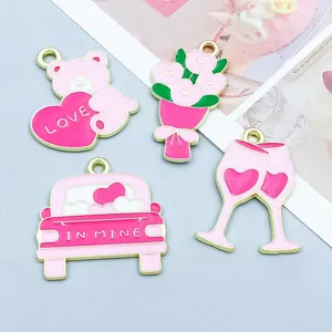 Détail de breloques en émail rose pour la Saint-Valentin avec ours cœur et flûtes