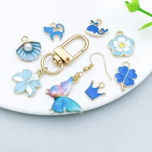 Detailed view of lake blue enamel charms including butterfly, flower, and shell pendants