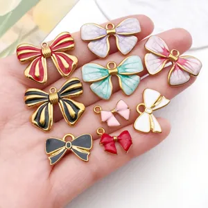 Detalle de colgantes de lazos coloridos de acero inoxidable y esmalte para bisutería DIY.
