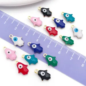 Detailed shot of colorful enamel Hamsa hand charms with evil eye on a scale ruler