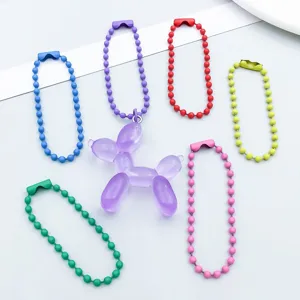 Detailed macro view of colorful lacquered bead chains and a purple balloon dog pendant