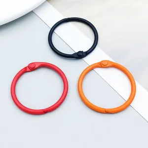 Detail of three colorful metal binder rings in black, red, and orange for DIY crafts