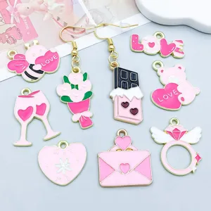 Close-up detail of various pink enamel Valentine's Day charms for DIY jewelry crafting