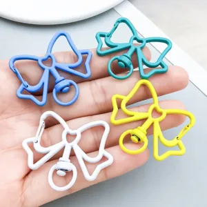 Macro view showing colorful bow-shaped alloy keychain hooks for DIY handmade crafts