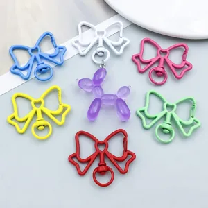 Macro detail of colorful alloy bow keychains featuring a purple balloon dog charm