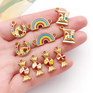 Detailed view of colorful enamel rainbow and candy charms held in palm for scale