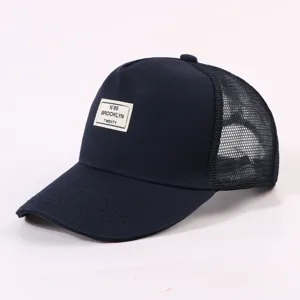 Nahaufnahme Detail der dunkelblauen Trucker Baseballcap mit stylischem Stoffaufnäher.