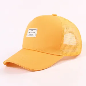 Nahaufnahme des gewebten Etiketts der gelben Trucker-Cap mit atmungsaktivem Mesh-Rückenteil.