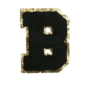 Close-up of black chenille letter B patch with shiny gold glitter border for DIY apparel.