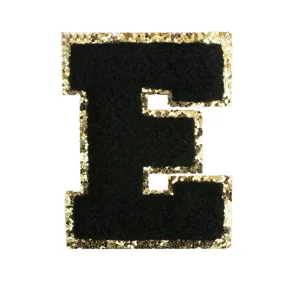 Black and gold glitter chenille letter E patch embroidery detail closeup view for DIY crafts.