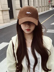 Detailed view of the brown baseball cap with white letter embroidery, stylish and versatile.