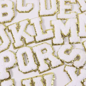 Close up detail of white chenille varsity letter patches with gold glitter border for apparel DIY.