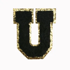 Close-up detail of the black and gold glitter letter U patch, textured chenille embroidery.