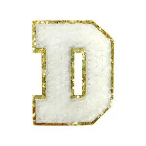 Detailed shot of white chenille letter D patch with gold glitter border for DIY clothing.