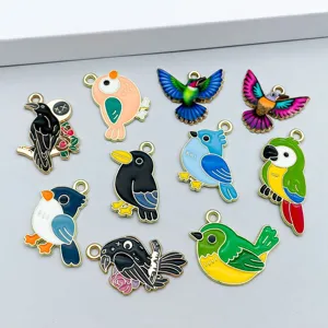 Détail de breloques oiseaux en émail coloré pour la création de bijoux DIY