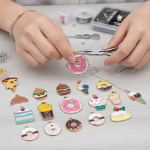 Detail of handmade jewelry process using colorful enamel food-themed cartoon charms