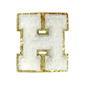 Close-up detail of white chenille letter H patch with sparkling gold glitter border for DIY.