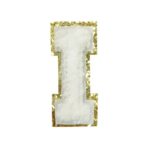 Close-up detail of the white towel embroidery letter I patch with shiny gold sequin border.