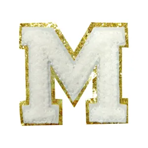 White chenille letter M patch detail, sparkling gold glitter border, DIY apparel accessory.