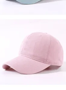 Plain pink cotton baseball cap detail shot showing soft crown, curved brim, and fine stitching.