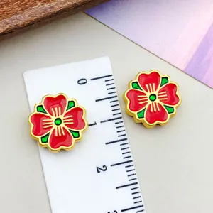 Detailed view of red enamel sakura flower spacer beads for DIY jewelry