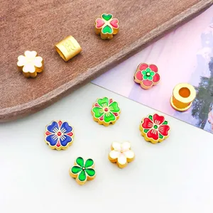Close-up of colorful enamel alloy flower and four-leaf clover spacer beads for jewelry DIY.